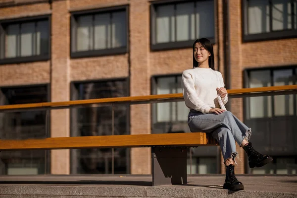 Binanın arka planında oturan kız bekliyor — Stok fotoğraf