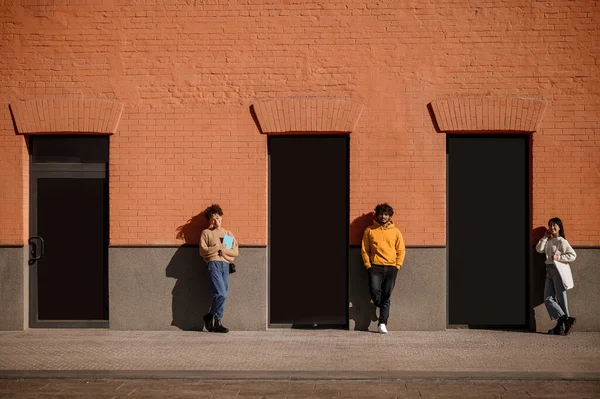 Adam ve iki kız binanın yanında bekliyorlar. — Stok fotoğraf