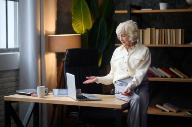 Gözlüklü kadın telefonda konuşuyor.