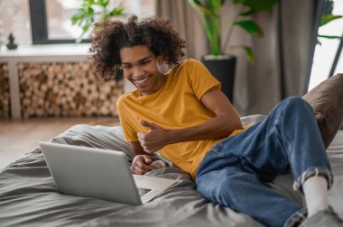 Kıvırcık saçlı genç melez evde dinleniyor.