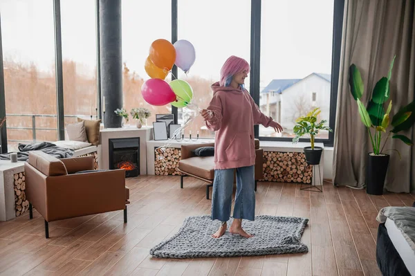 Ein fröhliches Mädchen tanzt mit einem Haufen bunter Luftballons — Stockfoto