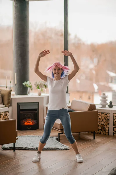 분홍색 머리의 소녀 가집에서 운동을 하고 있다 — 스톡 사진