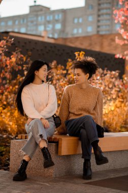 İki tatlı genç kız konuşuyor ve birbirlerine bakıyorlar.