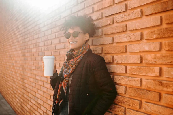 Una linda chica en gafas de sol tomando café afuera — Foto de Stock