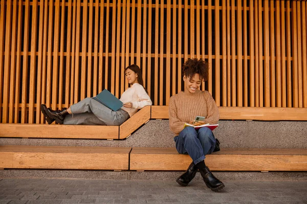 Dos chicas sentadas en el pabellón y estudiando — Foto de Stock