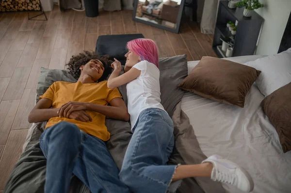 Young couple laying in bed and looking relaxed — Stock Photo, Image