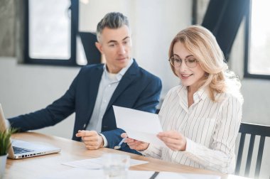 İki iş ortağı yeni teklifi tartışıyor ve olaya dahil oluyor.