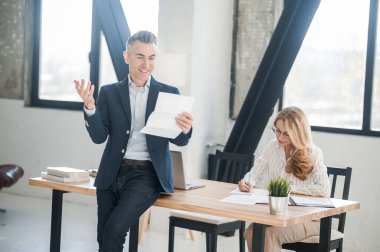 Elinde belgelerle takım elbiseli bir adam.