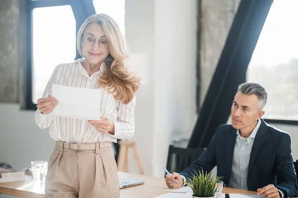 A blonde elegant woman in the offcie with documents in hands — Stock Photo, Image