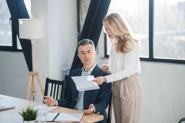 Blonde woman showing na document to her boss — Stock Photo, Image