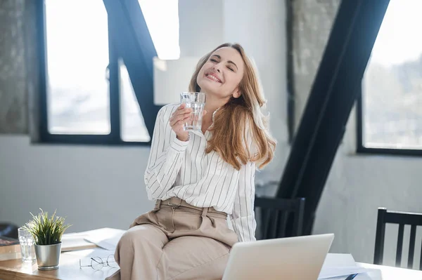 A cute woman sitting on the table in the offcie — Stock Photo, Image