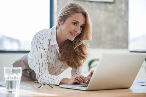 A cute elegant woman in the office working on laptop — Stock Photo, Image