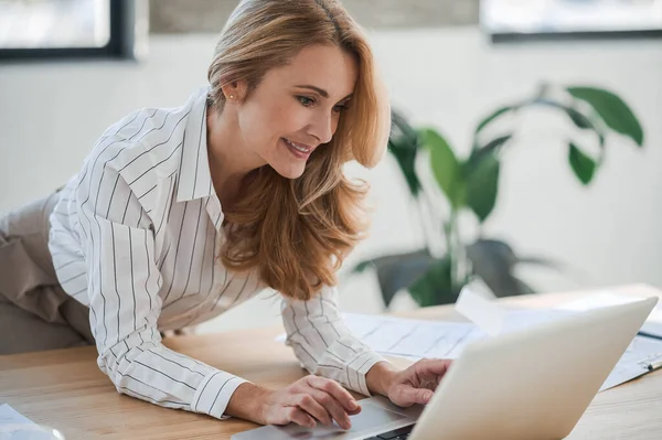 A cute elegant woman in the office working on laptop — Stock Photo, Image