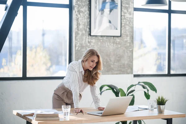 A cute elegant woman in the office working on laptop — Stock Photo, Image