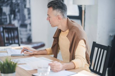 Ofiste evrakları incelerken olaya karışan bir adam var.