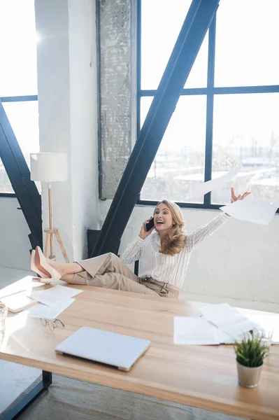 A blone businesswoman in her office talking on the phone — Stock Photo, Image