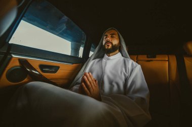 Deri bir arabanın içinde genç, zengin bir Suudi.