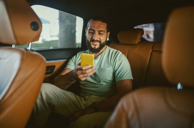 Arabada telefonla konuşan yakışıklı bir genç adam.