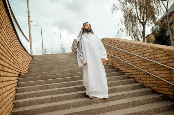 Un hombre árabe con ropa blanca tradicional en las escaleras — Foto de Stock