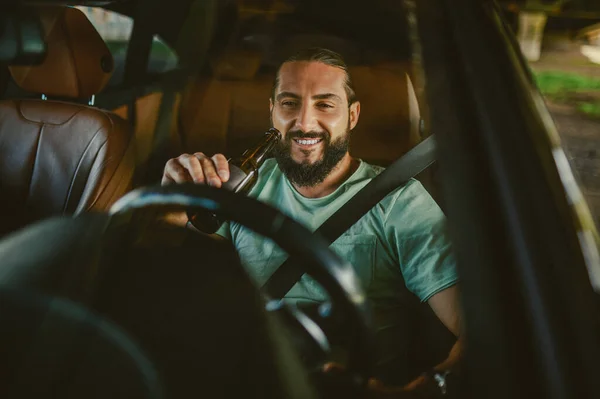 Joven guapo moreno conduciendo un coche y sonriendo — Foto de Stock