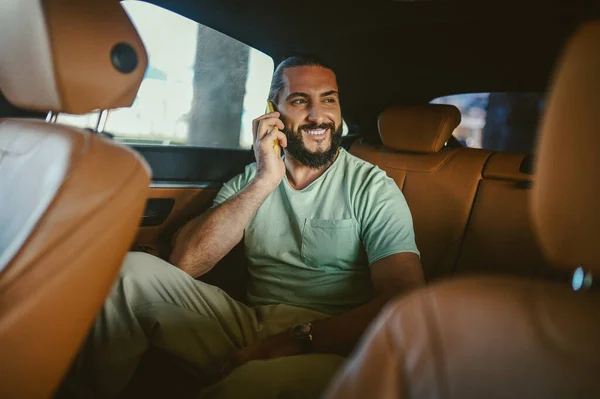 Un joven guapo hablando por teléfono en un coche — Foto de Stock