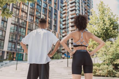 Gençler. Spor giyim sektöründe iki genç binanın arka planında dikiliyor.