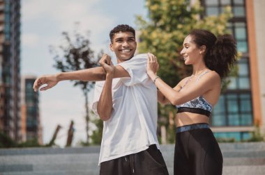 Antrenman yapıyorum. Bir kız ve bir erkek dışarıda antrenman yapıyor.