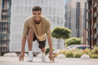 Antrenman yapıyorum. Yakışıklı genç adam antrenman yapıyor ve aktif görünüyor.