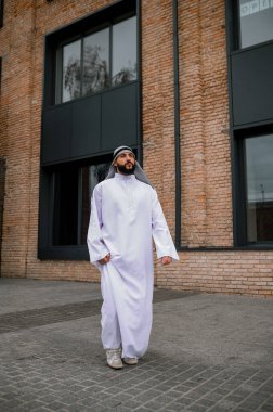 Arap adam. Şehir sokaklarında geleneksel kıyafet giyen bir adam.