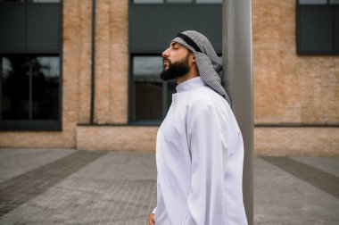 Arap adam. Şehir sokaklarında geleneksel kıyafet giyen bir adam.