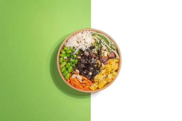 Bir kase salata dürüm ve ton balığı, havuç, salatalık ve ananas arka planda ikiye bölünmüş, yeşil ve beyaz, sağlıklı yiyecek, insan yok.