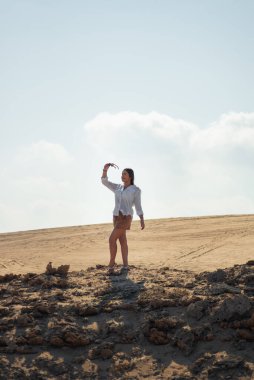 Genç Meksikalı Latin, tamulipas, Meksika, güneşli bir gün ve Tampico 'da turistik bir yerde bazı kayaların üzerinde poz veriyor.