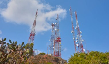 Çöl ormanının ortasındaki bir dağın tepesinde iletişim kuleleri, yaz günü mavi gökyüzü, insanlar, kayalar ve palmiyeler yok.