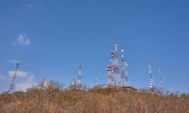 Çöl ormanının ortasındaki bir dağın tepesinde iletişim kuleleri, yaz günü mavi gökyüzü, insanlar, kayalar ve palmiyeler yok.