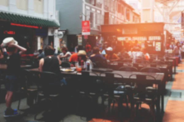 Arkaplanı bulanık insanlar ve sokak yiyecekleri pazarı sıcak ışıklı..