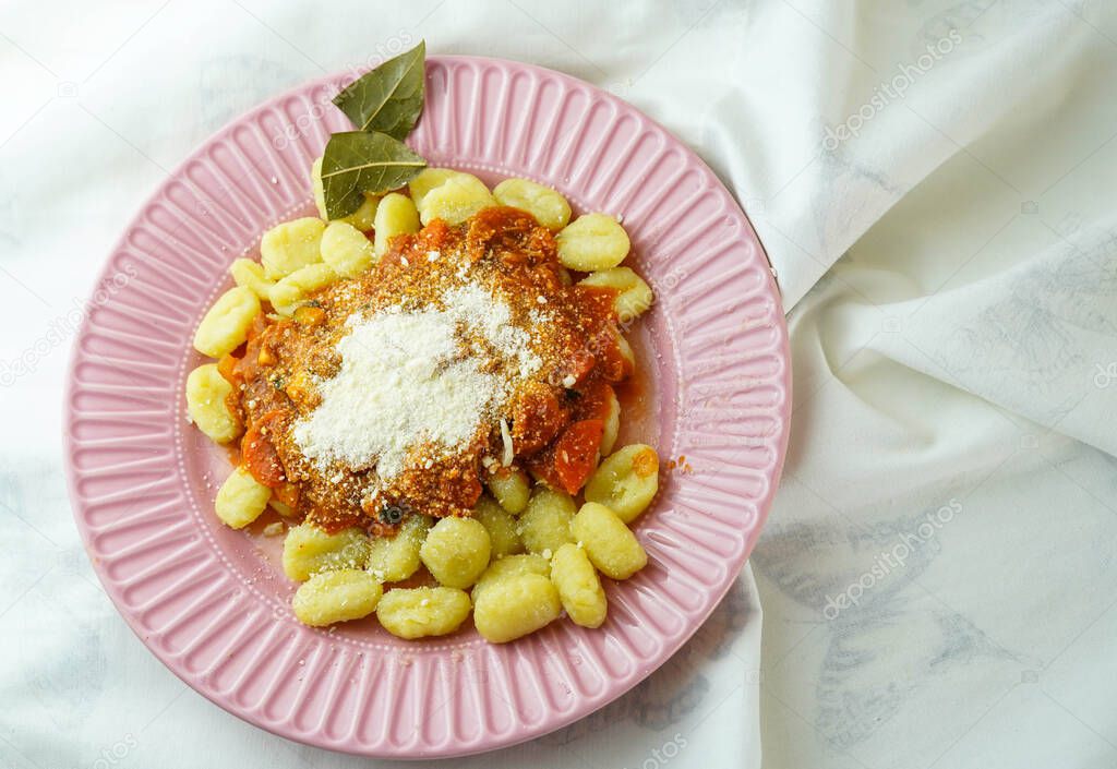 Plate of fresh gnocchi with tomato sauce and grated Parmesan cheese