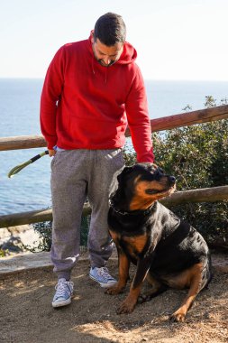 Parkta Rottweiler köpeğiyle oynayan adam