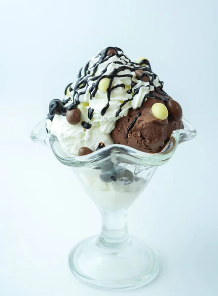 Scoops of ice cream with chocolate balls and syrup
