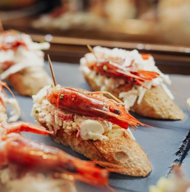 Yengeç, jambon ve sebzeli çeşitli ekmek kanepeleri.