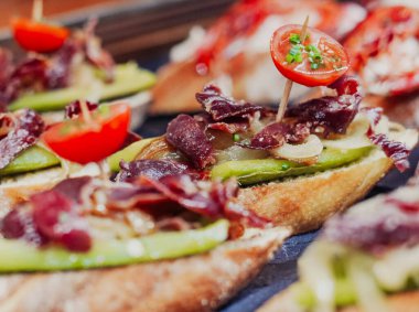 Yengeç, jambon ve sebzeli çeşitli ekmek kanepeleri.