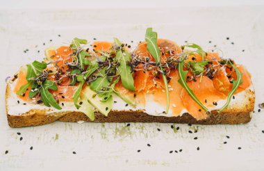 Somon tostu, taze peynir, avokado ve roka.