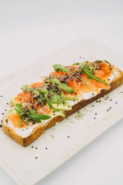 Somon tostu, taze peynir, avokado ve roka.