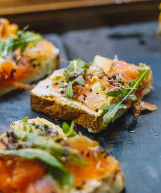 Somon tostu, taze peynir, avokado ve roka.