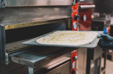 Bir uzman tarafından yapılan ev yapımı İtalyan usulü pizzanın hazırlanması
