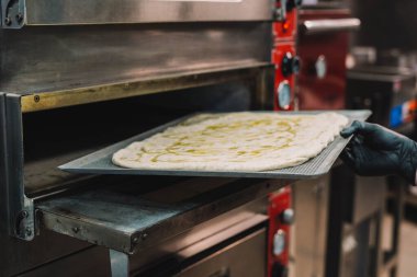 Bir uzman tarafından yapılan ev yapımı İtalyan usulü pizzanın hazırlanması