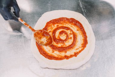 Bir uzman tarafından yapılan ev yapımı İtalyan usulü pizzanın hazırlanması