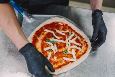 Bir uzman tarafından yapılan ev yapımı İtalyan usulü pizzanın hazırlanması