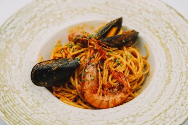 Bir tabak spagetti, deniz ürünü ve domates soslu.