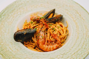 Bir tabak spagetti, deniz ürünü ve domates soslu.
