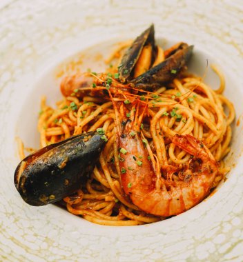 Bir tabak spagetti, deniz ürünü ve domates soslu.
